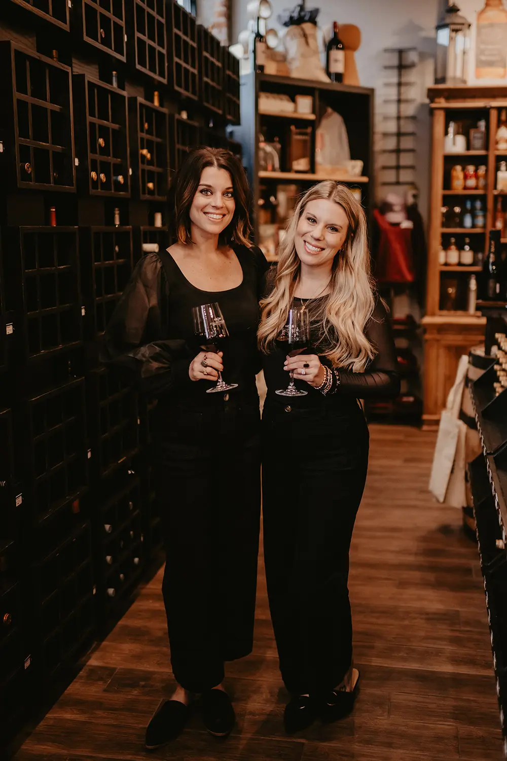 The stock sisters standing and each holding a glass of wine